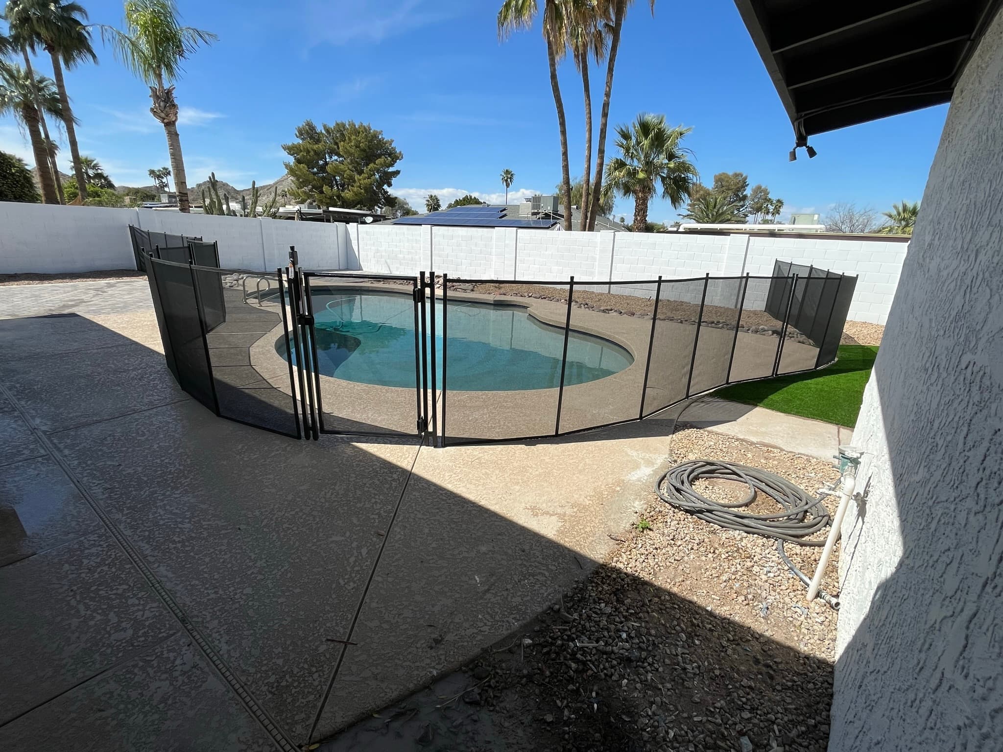 Black mesh pool fence installed around full pool perimeter — Maricopa County