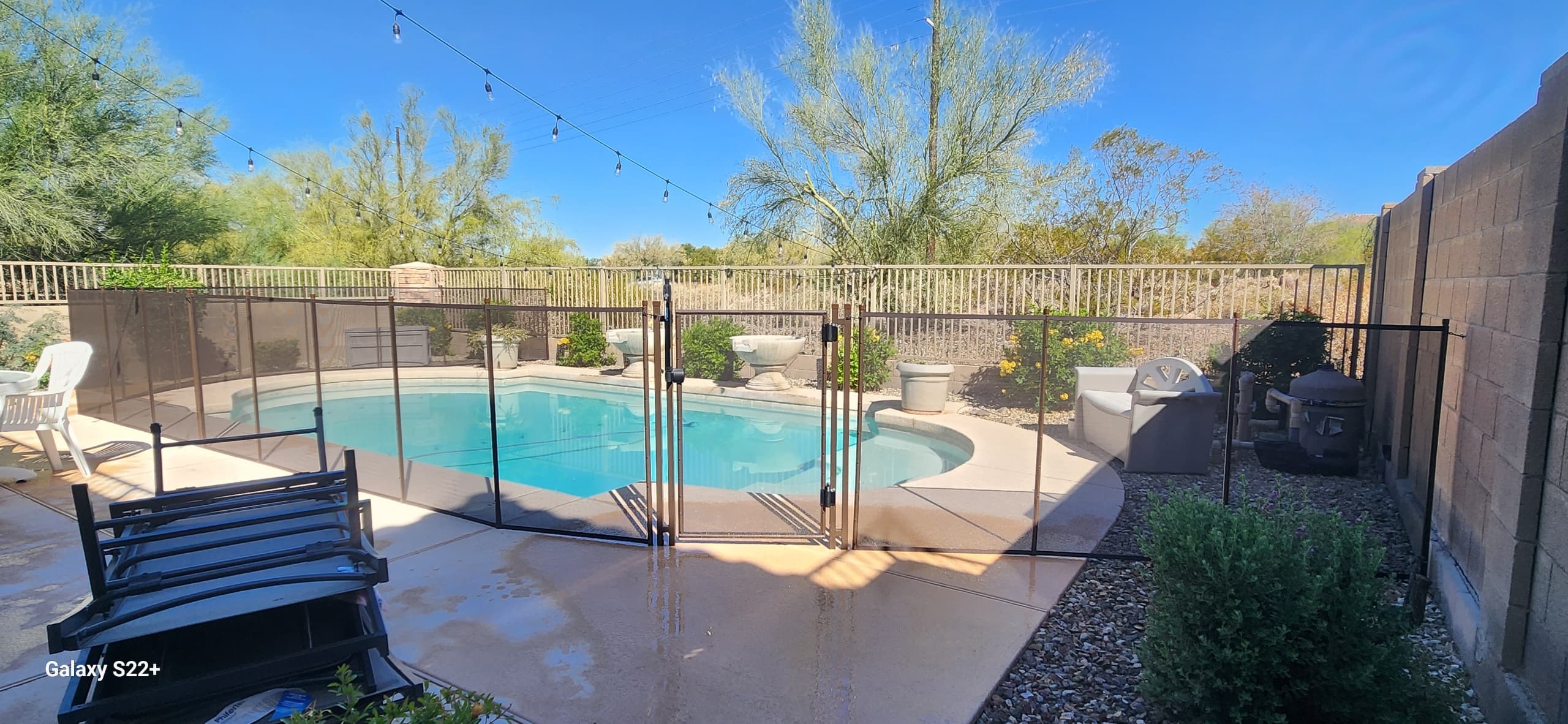 Pool fence around round pool — string lights, Arizona backyard installation